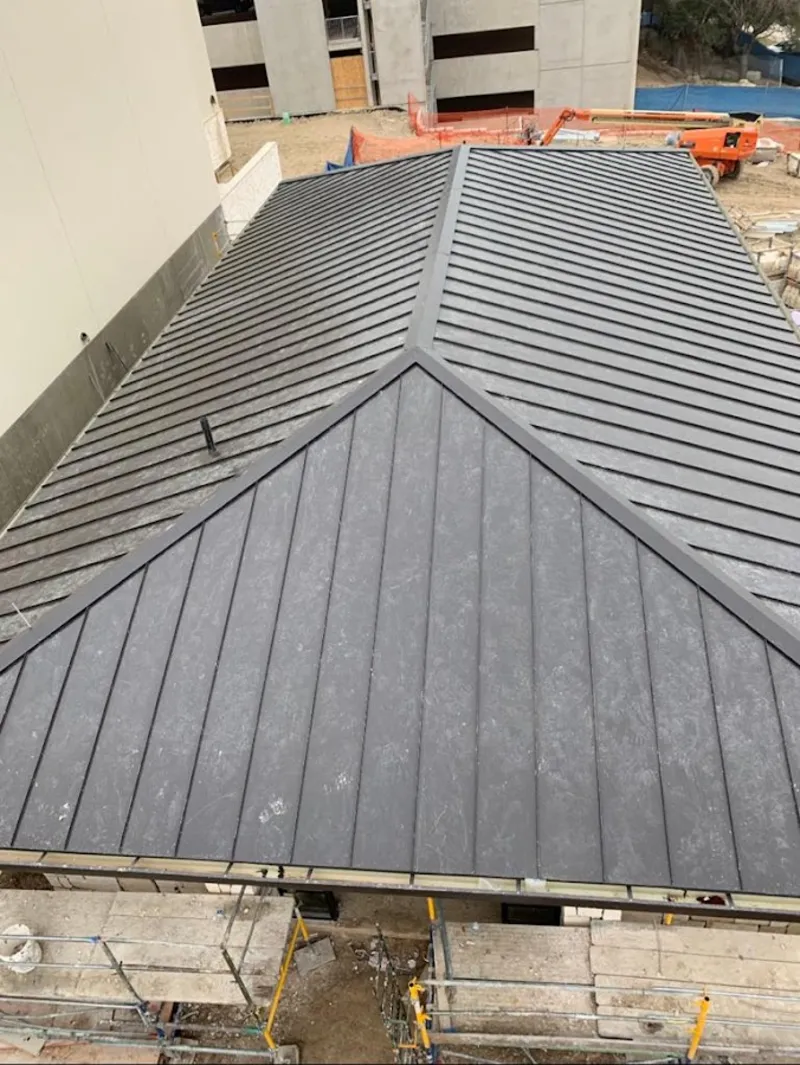 Commercial metal roof construction with crane equipment in North Port